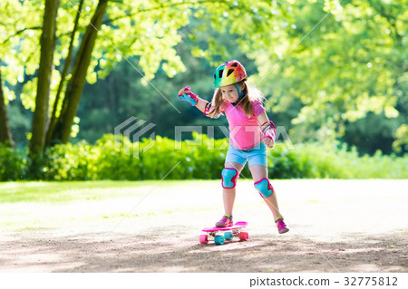 Child riding skateboard in summer park 32775812