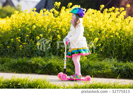 Child riding schooter on way to school 32775813
