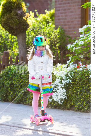 Child riding schooter on way to school 32775827