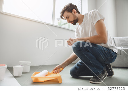 Young man does apartment repairment himself 32778223