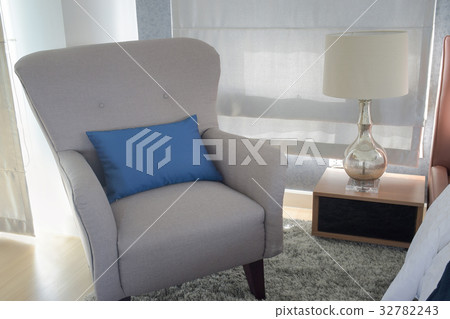 Retro style armchair with pillow next to bed 32782243