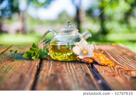 Tea pot of herbal tea on a wooden table 32787610