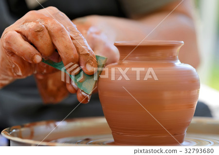Potter making ceramic pot on the pottery wheel 32793680