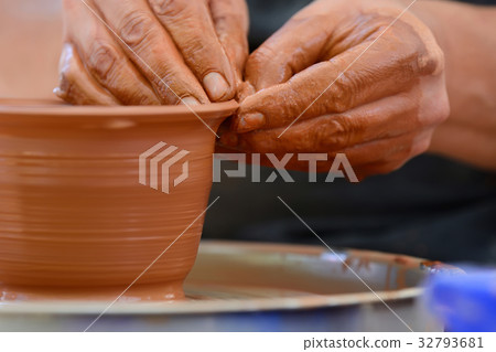 Potter making ceramic pot on the pottery wheel 32793681
