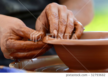 Potter making ceramic pot on the pottery wheel 32793682