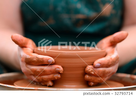 Potter making ceramic pot on the pottery wheel 32793714