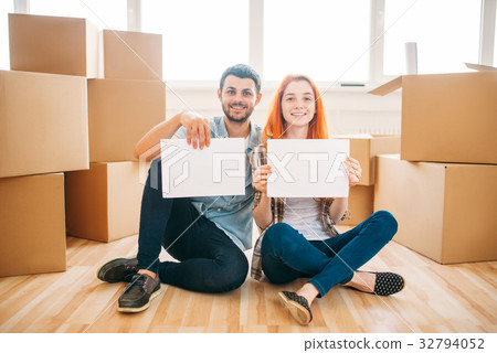 Couple sitting on floor with empty paper sheets Couple sitting on floor with empty paper sheets 32794052