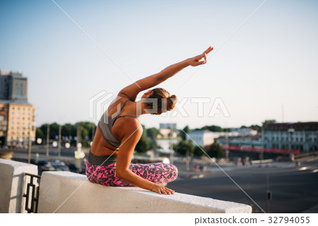 Young woman in yoga pose, city on background Young woman in yoga pose, city on background 32794055