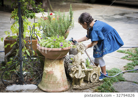 Girl giving water to a flower 32794826