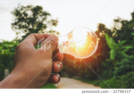 hand hold light bulb and sunset energy concept  32796337