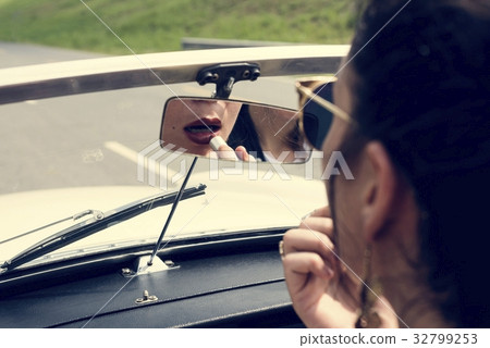 Woman Sitting in a Car Putting Lipstick on Lips with Rear Mirror Woman Sitting in a Car Putting Lipstick on Lips with Rear Mirror 32799253