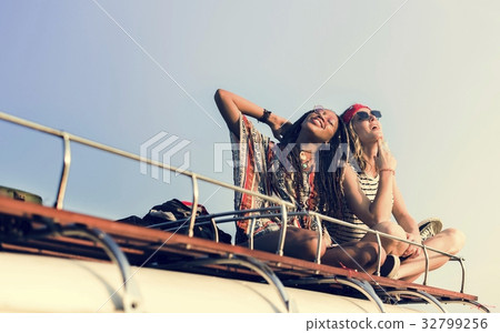 Women Sitting on The Roof of the Van Traveling Road Trip Women Sitting on The Roof of the Van Traveling Road Trip 32799256