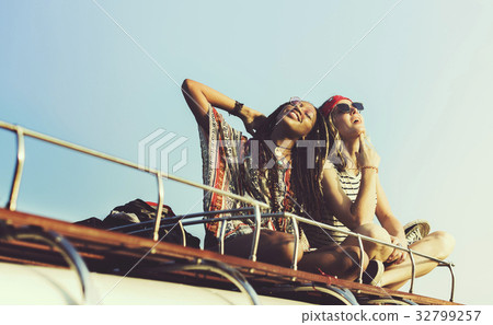 Women Sitting on The Roof of the Van Traveling Road Trip Women Sitting on The Roof of the Van Traveling Road Trip 32799257
