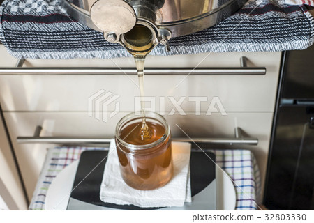 Beekeeper filling up the fresh golden new honey Beekeeper filling up the fresh golden new honey 32803330