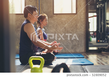 Portrait of pretty girl training in gym with her trainer helping 32809052