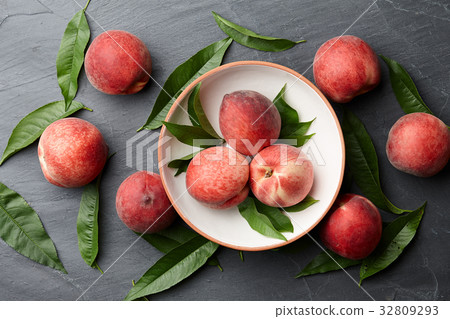 Fresh peaches fruits with leaves on stone background Fresh peaches fruits with leaves on stone background 32809293