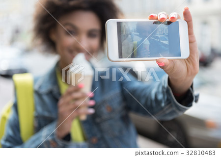 Cheerful young woman is doing her picture using Cheerful young woman is doing her picture using 32810483