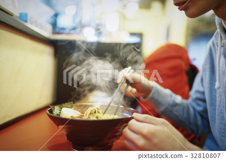 A man eating Sapporo ramen 32810807