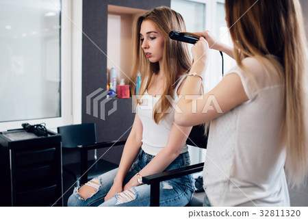 Hairdresser working on young girl s hairstyle 32811320
