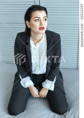 Beautiful and sad woman kneeling in bed. Beautiful and sad woman kneeling in bed. 32812397