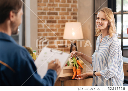 Pretty delighted lady examining contents of the 32813516