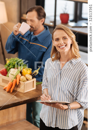 Stunning sincere woman offering courier some tea 32813561