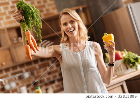 Dynamic vibrant lady holding some veggies in her 32813899