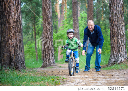 Happy cute blond kid boy having fun his first bike Happy cute blond kid boy having fun his first bike 32814271