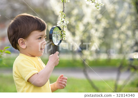 Young boy exploring nature with magnifying glass Young boy exploring nature with magnifying glass 32814340