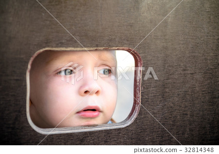 Curious kid spying through the hole in the wall 32814348