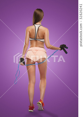 Muscular young woman athlete posing at studio 32820241