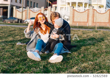 happy mom dad and son hugging in the park 32822569