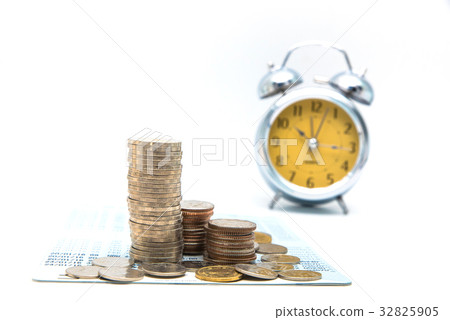 Stack of coins with vintage clock on white Stack of coins with vintage clock on white 32825905