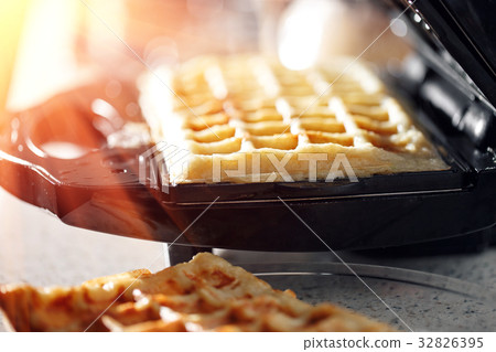 Freshly baked traditional Belgian waffles in iron Freshly baked traditional Belgian waffles in iron 32826395