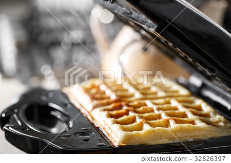 Freshly baked traditional Belgian waffles in iron Freshly baked traditional Belgian waffles in iron 32826397