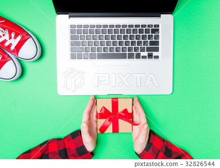 Female hands and gift box with gumshoes Female hands and gift box with gumshoes 32826544