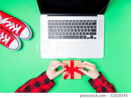 Female hands and gift box with gumshoes Female hands and gift box with gumshoes 32826545