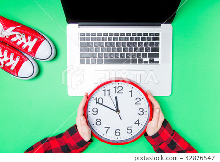 hands and huge clock with gumshoes near laptop hands and huge clock with gumshoes near laptop 32826547