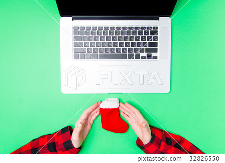 Female hands holding sock near laptop Female hands holding sock near laptop 32826550