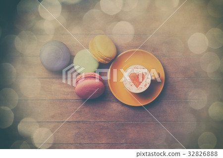 Cup and macarons on wooden background 32826888