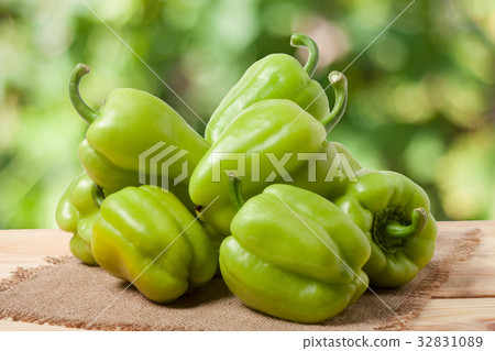 pile green pepper on a wooden table with blurred 32831089