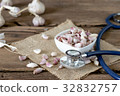 seed garlic and stethoscope on old wooden table 32832757