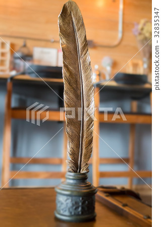 Metal bird feather on leather background Metal bird feather on leather background 32835347