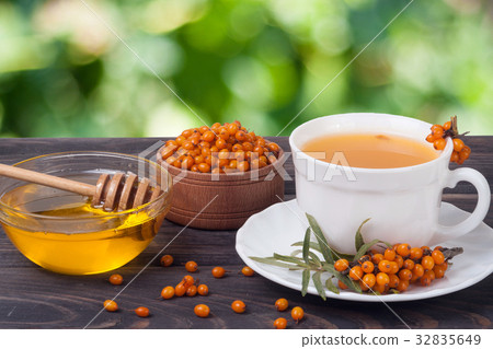 Tea of sea-buckthorn berries with honey on wooden Tea of sea-buckthorn berries with honey on wooden 32835649