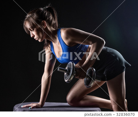 Brunette girl during workout with dumbbells Brunette girl during workout with dumbbells 32836070