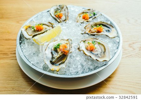 Raw and fresh oyster shell with lemon Raw and fresh oyster shell with lemon 32842591
