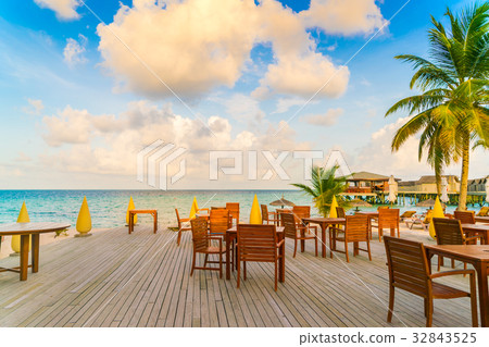 Table and chairs at restaurant in tropical Maldives island . Table and chairs at restaurant in tropical Maldives island . 32843525