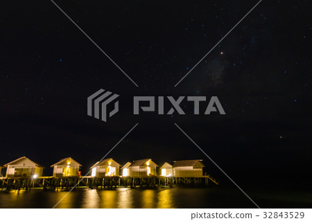 Milky Way over water villa cottages on Maldives . Milky Way over water villa cottages on Maldives . 32843529