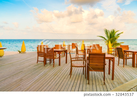 Table and chairs at restaurant in tropical Maldives island . Table and chairs at restaurant in tropical Maldives island . 32843537