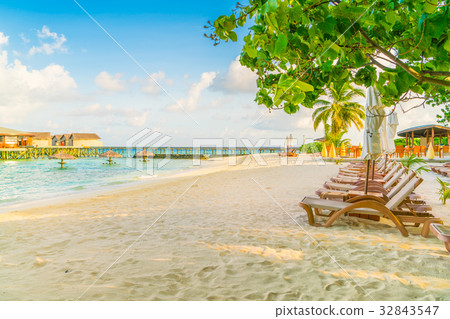 Beach chairs with umbrella at Maldives island, white sandy beach and sea . Beach chairs with umbrella at Maldives island, white sandy beach and sea . 32843547